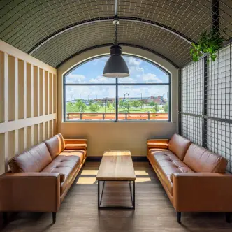 Bright lounge seating area with leather sofas by an arched window